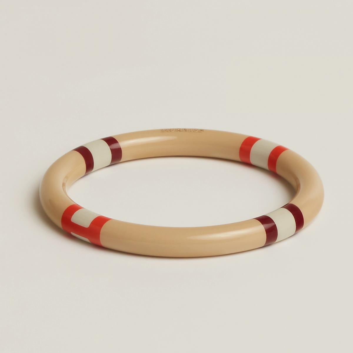 來自越南工坊的漆木工藝，將牛角與木材巧妙融合，H 字母被圓形環繞，令人聯想到愛馬仕標誌性的家徽圖案。