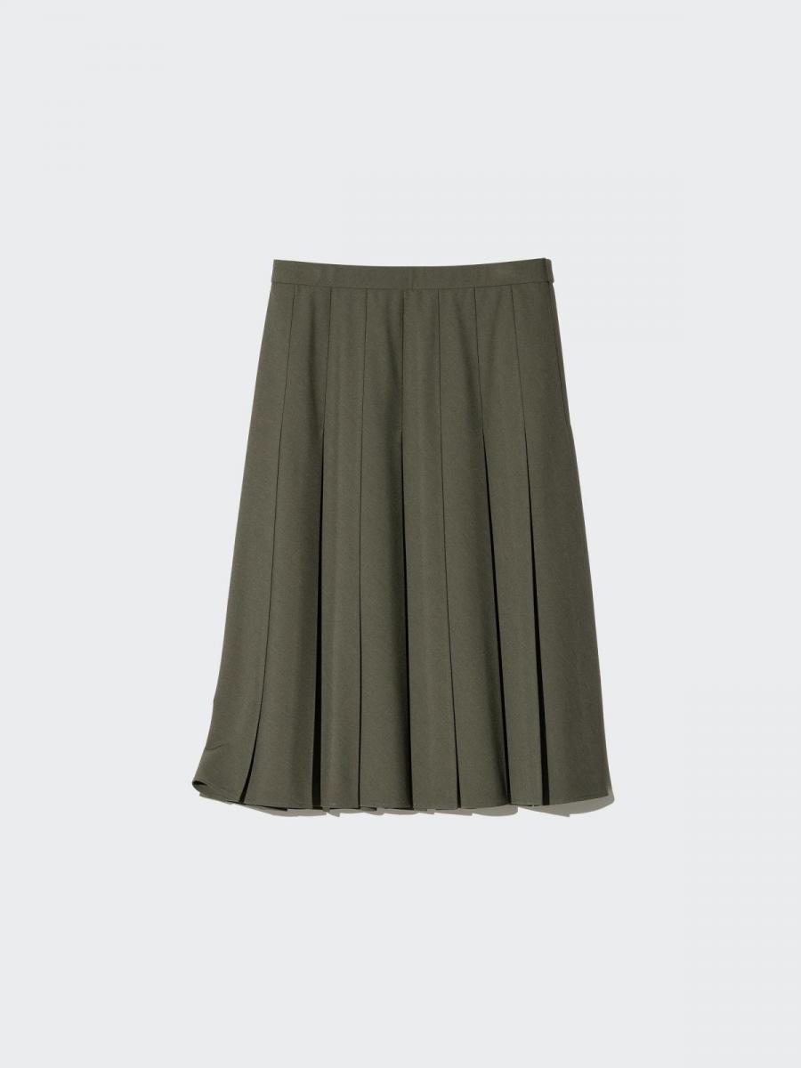 這件中長度的百褶裙，在設計上藉由緊貼腹部的壓摺設計達到提高腰線、遮小腹的功用外，同時內摺的壓紋設計，更降低其嚴肅感，使整體多了幾分時髦度。