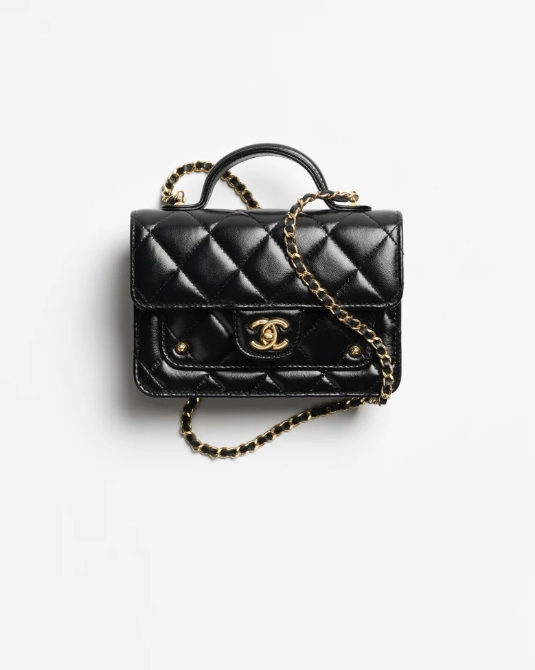   這款黑色包袋，運用亮面的皮革為設計主軸，在外型上將品牌經典口蓋包等比縮小，讓整體變得更為精巧、可愛，端看細節除了集結標誌性的元素於一身外。