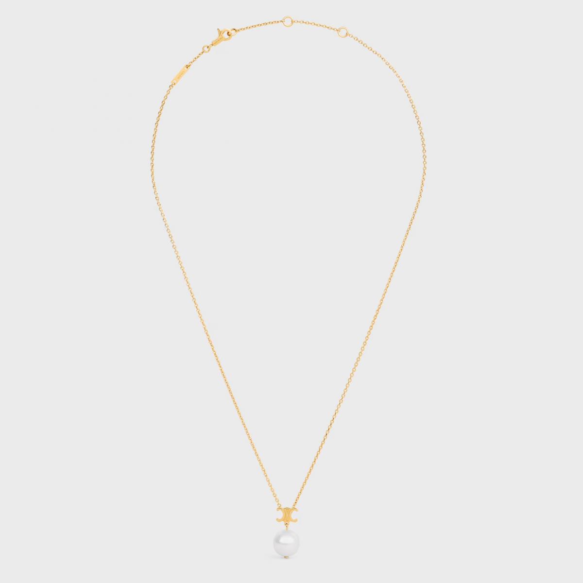 Celine 的 Les Perles 項鍊，以簡潔乾淨的線條彰顯品牌一貫的冷調極簡。中央的 Triomphe 凱旋門吊墜，是品牌最具代表性的符號之一，與下方的一顆圓形樹脂珍珠相連，簡單卻意味深長。