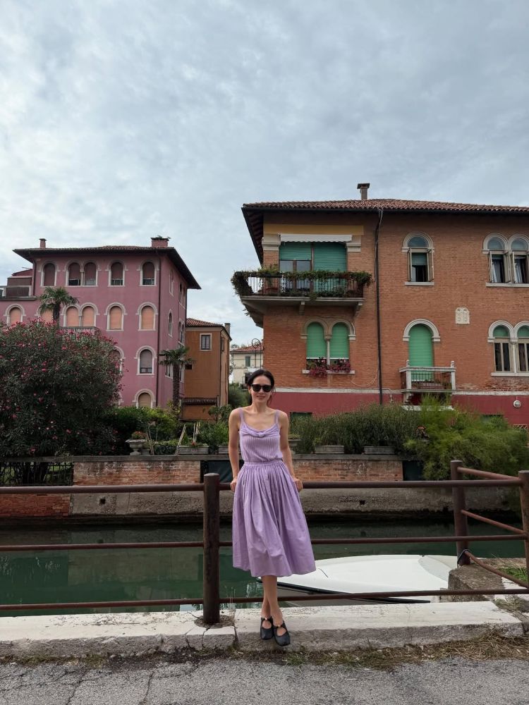 在義大利街頭的悠閒場景中,孫藝珍選擇以淡紫色洋裝搭配Loewe瑪莉珍鞋,詮釋了旅行穿搭的最佳示範。