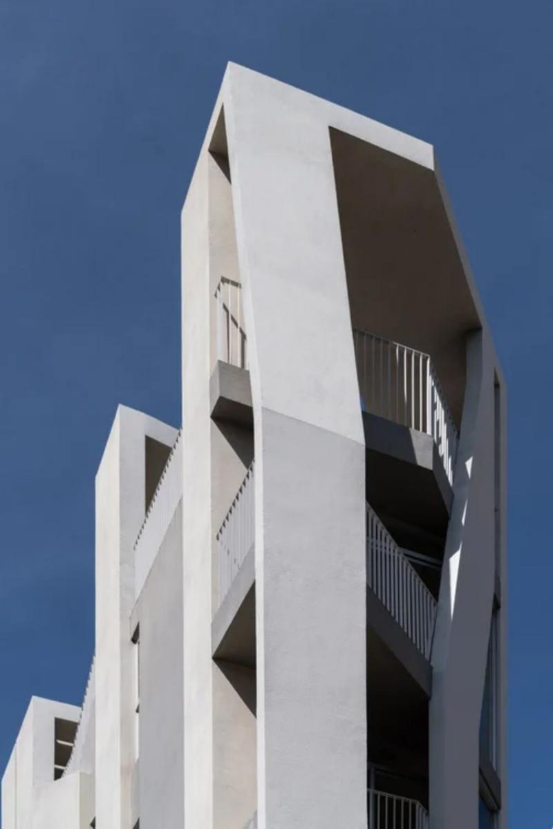 共居之家最大的亮點之一，在於空間樓板與動線設計。透過垂直錯層與移動形塑交錯佈局，嘗試弱化傳統單調的樓層立面。藉由動線的環繞、空間的錯層、結構與外觀的融合，透過垂直樓梯設計，穿越於結構與外牆之間，帶領居住者一路走至屋頂花園。結合互動性與趣味性的住宅空間，重新定義公寓住宅的形式，為老舊都市街廓注入嶄新活力。