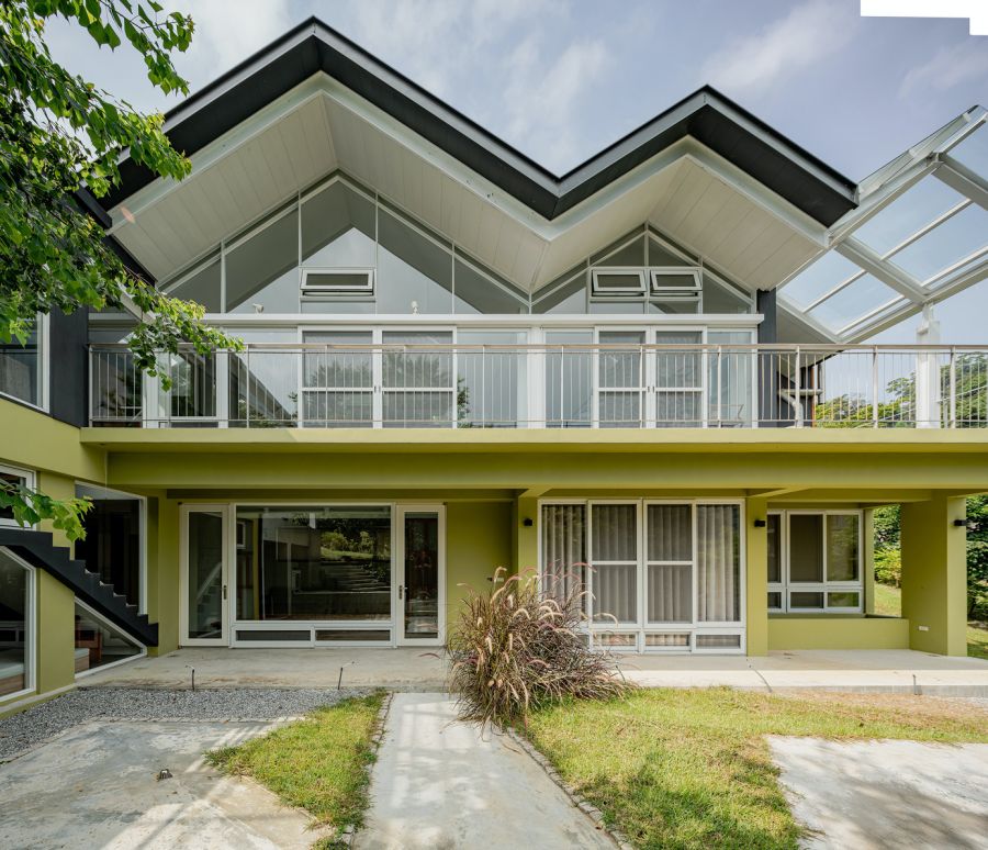 挑高的客廳空間，成為入室的一處驚喜。下沉式的地板設計形塑空間的層次性，同時也增加家人間的凝聚力。山簷屋頂下的空間同時也是開放、連續、流動的生活場，轉譯連綿山巒的語彙，彷彿置身於山脈之下。透過動線與家具的擺設，注入更多溫暖的情感氛圍。立面上，建築師也嘗試開了多扇幾何窗，透過大面積的玻璃及木格柵，堆砌出陰影的層次變化。