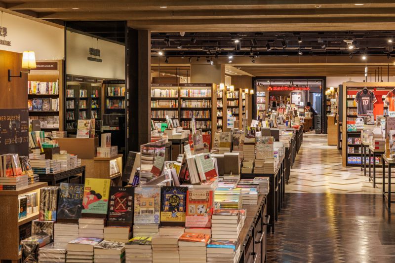 除了揉入誠品敦南店的「坐讀階梯」,松菸 24 小時書店也打造全新 40 米的閱讀長廊,重塑過往誠品信義店的寬敞書冊廊道,總書量更擴增 1 成,達到 25 萬冊。不僅藉由寬敞的走道形塑書店氛圍,也透過書架中島設計,讓閱讀者能自由地穿梭於書海中,結合書櫃排列與小檯燈,增添一抹溫度。