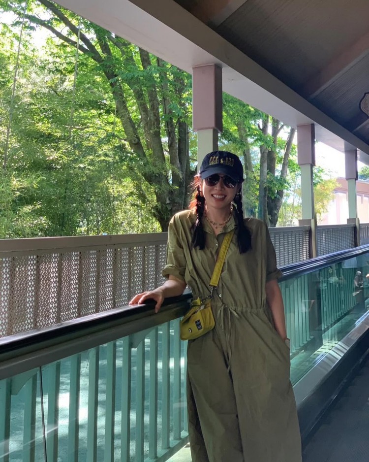 軍綠色連身套裝的低調充滿早秋氣息，線條俐落而不拘謹，孫藝珍將袖口自然捲起，腰間束繩則在不經意間拉出修長比例。