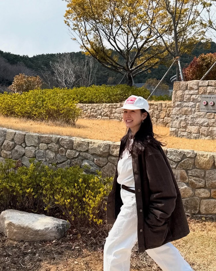 以全白基底的T-shirt與牛仔褲，外搭一件咖啡色工裝夾克，瞬間提升層次與氣勢。