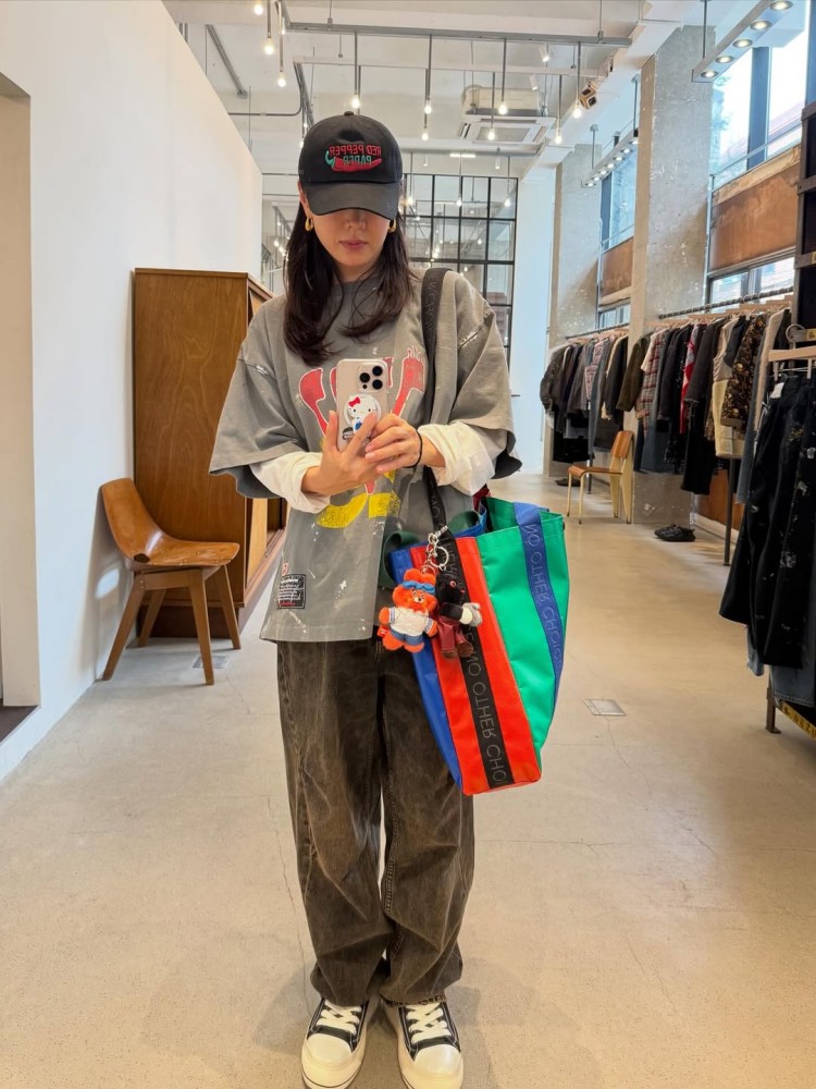 這套造型完美展現孫藝珍「鬆弛系減齡」的穿搭精髓。她以寬鬆的灰色印花 T-shirt 疊穿白色長袖，營造出層次感與隨性氛圍，再搭配水洗牛仔寬褲與厚底帆布鞋，整體比例不僅顯瘦還透出滿滿的青春感。