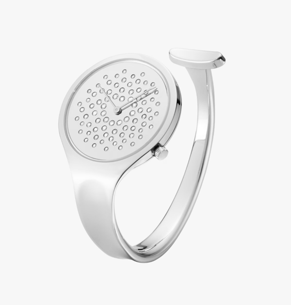 當時間不再被數字框限，戴在手腕上的錶，也能成為自由的象徵。1967年，設計師薇薇安娜 · 朵蘭（Vivianna Torun）為Georg Jensen創作出顛覆性的「Vivianna Bangle」手鐲錶，完美融合了手錶的功能和珠寶的美麗，以其無時標、無錶帶，僅以極簡線條與開放式手鐲，傳遞時間的詩意與哲思。