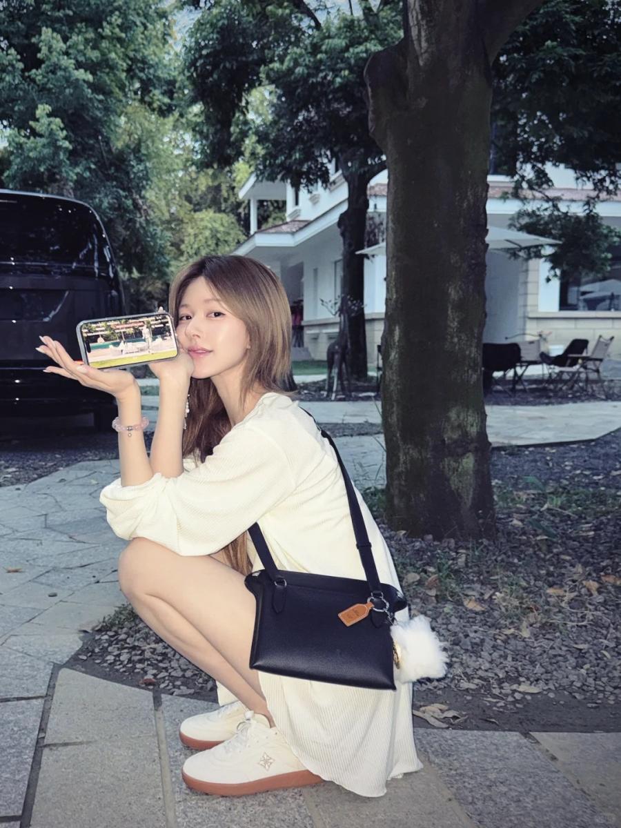 趙露思這套「白色系穿搭」，以米白色襯衫洋裝為主角，搭配奶白厚底球鞋延伸整體色調，營造從頭到腳一致的柔和氛圍，但巧妙搭配黑色斜背包作為視覺焦點。寬鬆剪裁讓比例更顯修長，舉手投足間流露出自然不造作的慵懶感。