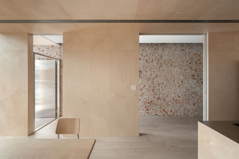 原始紅磚立面，是設計師刻意保留的老屋結構肌理。透過不同尺度的牆面開口，在導入光線與穿透感之餘，也為建築增添厚實的文化底蘊。不僅是一座住宅，更像是一段被重新書寫的街屋記憶。以「二樓梯間」為界，設計師重新編排建築機能：一側為共享辦公空間，另一側作為居住單元。二樓居住區中整合玄關、衣帽間與洗衣家事功能；三樓則以最精簡的睡眠空間，換取舒適開闊的公共尺度。