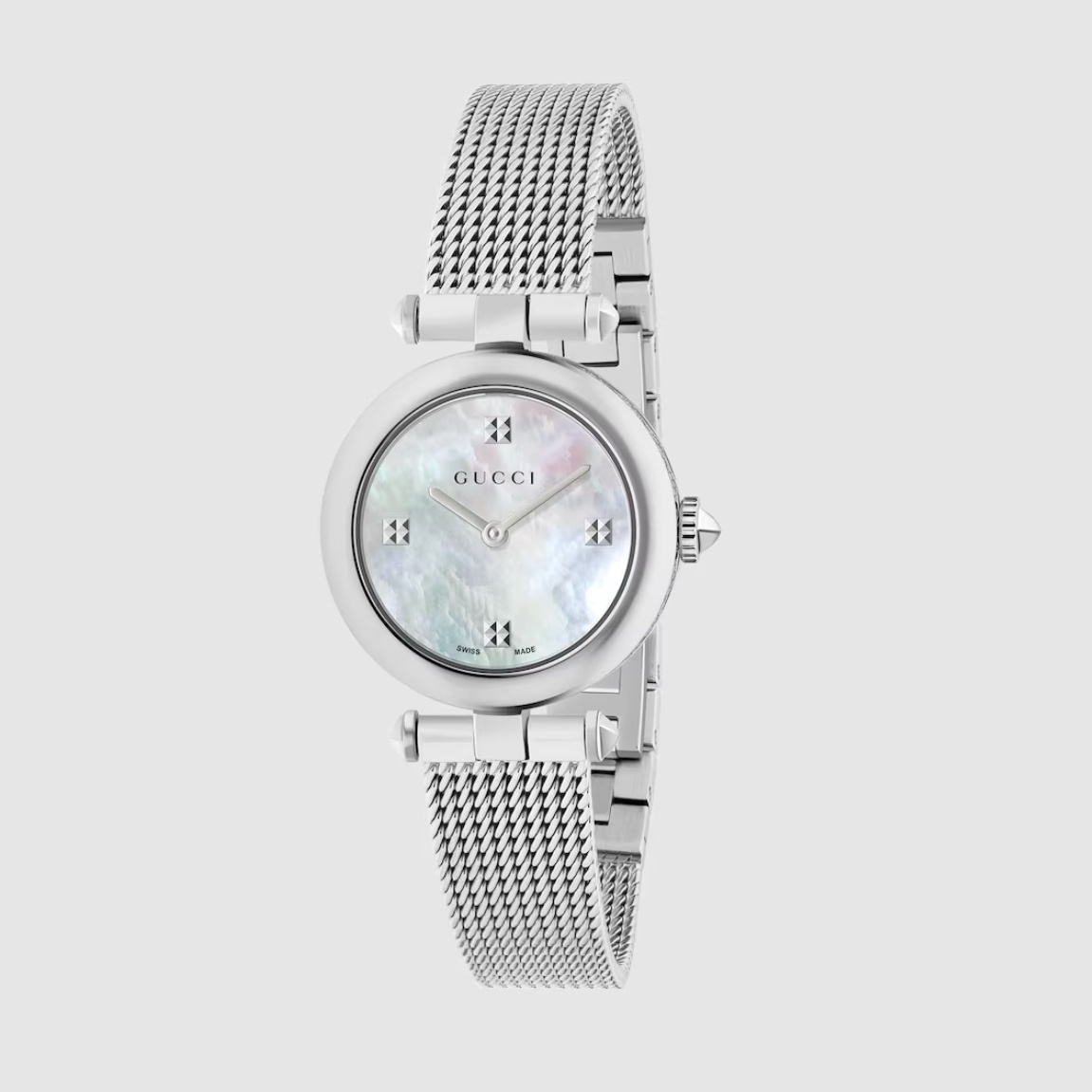 如果妳偏好帶點珠寶氣息的設計，Gucci 的 Diamantissima 腕錶會讓人一見傾心。它的亮點在於錶殼上那圈標誌性「鑽石紋圖案」，以細緻的幾何壓紋表現品牌經典美學。白色珍珠母貝錶盤散發柔光，與米蘭織紋精鋼鍊帶相互呼應，氣質清爽又具辨識度。錶徑僅27毫米，無論單戴或疊搭手鍊都顯得精緻俐落。瑞士製造的石英機芯提供可靠精準度，適合在辦公室與晚宴間自由切換的女性，展現一種含蓄而聰明的時髦。