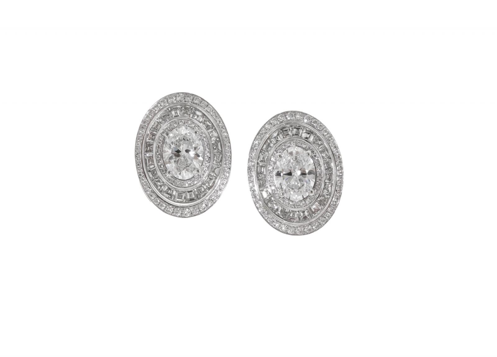 BVLGARI 頂級鑽石耳環，以白K金打造的橢圓形設計，鑲嵌兩顆主鑽與40顆花式階梯形切割鑽石，外圈密鑲細鑽層層堆疊，如同光的迴旋，展現寶格麗一貫的羅馬建築美學。