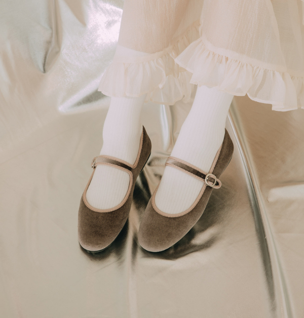 散發淡雅浪漫氣息的Grace Gift粉藕色瑪莉珍平底鞋,以細緻絨布質地詮釋柔和氛圍,低調中透出迷人質感。圓潤優雅的鞋楦線條自然修飾腳型,悄悄拉提整體比例,讓步伐間多了幾分輕盈與秀氣。