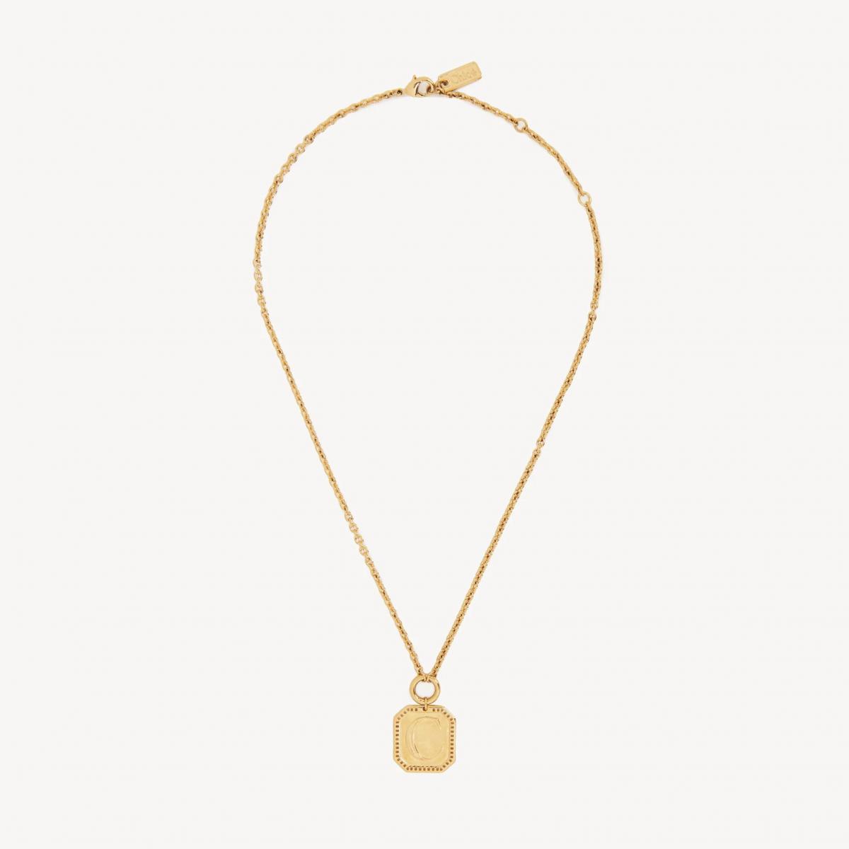 Chloé 的 Charms 吊墜項鍊,將品牌 DNA 中的波希米亞氣質轉化為一枚可佩戴的護身符。復古金色黃銅搭配八角形邊框與「C」字 Logo 吊墜,細節處綴以精緻刻紋與小標牌,營造手工飾品般的溫度。它不像一般標誌項鍊那樣銳利,反而多了幾分溫柔與詩意,是文藝女子衣櫥中最能展現個性的那一抹金光。