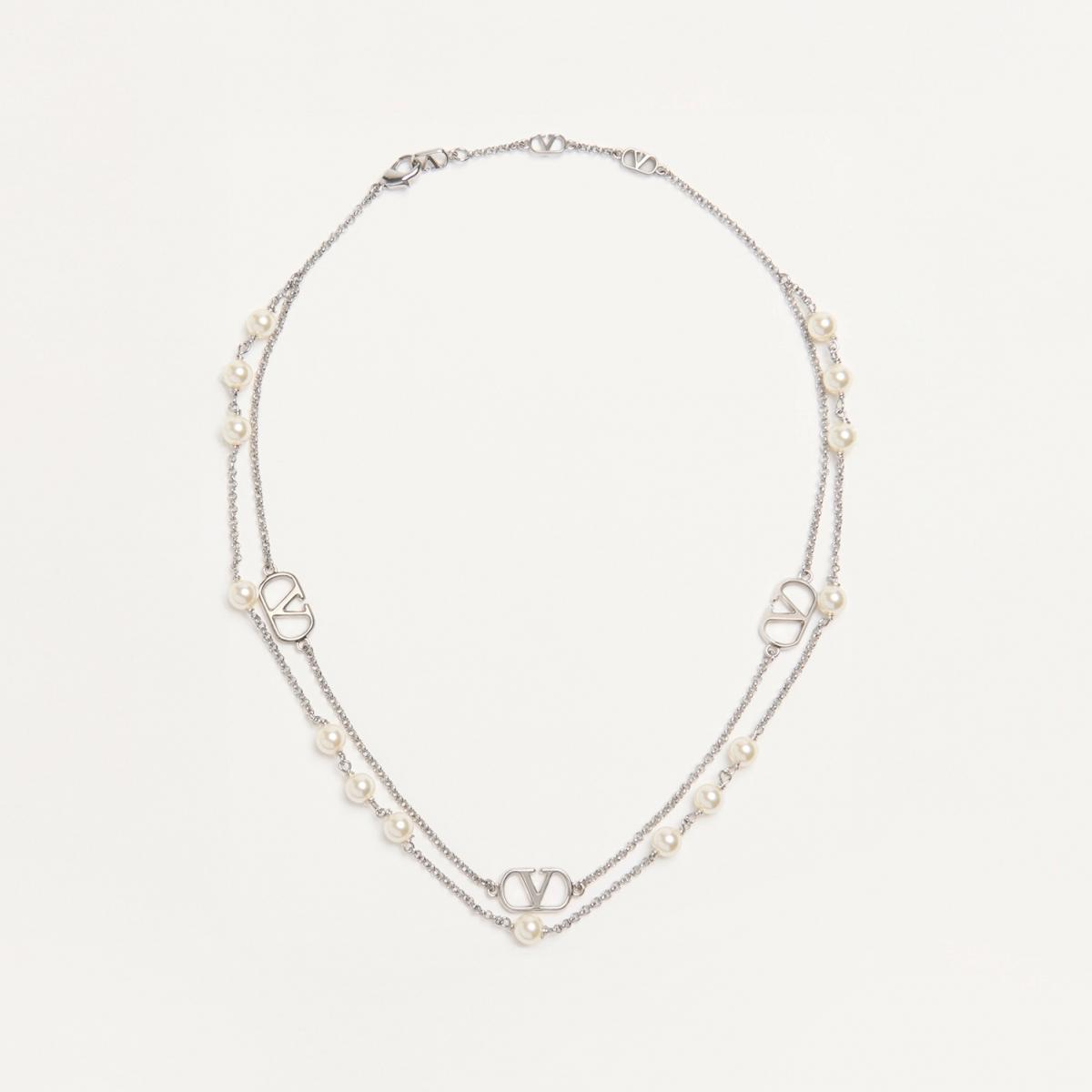 Valentino 的 VLogo Signature 頸鍊以雙鍊設計營造層次美感，一條點綴仿珍珠，一條懸掛經典 VLogo 吊墜，展現義式華麗的細膩浪漫。鍍鈀金屬光澤映襯出柔和珍珠光，彷彿剛柔共存的愛情故事。無論搭配襯衫或洋裝，都能散發不費力的高級感，是職場與約會都能駕馭的萬用款。