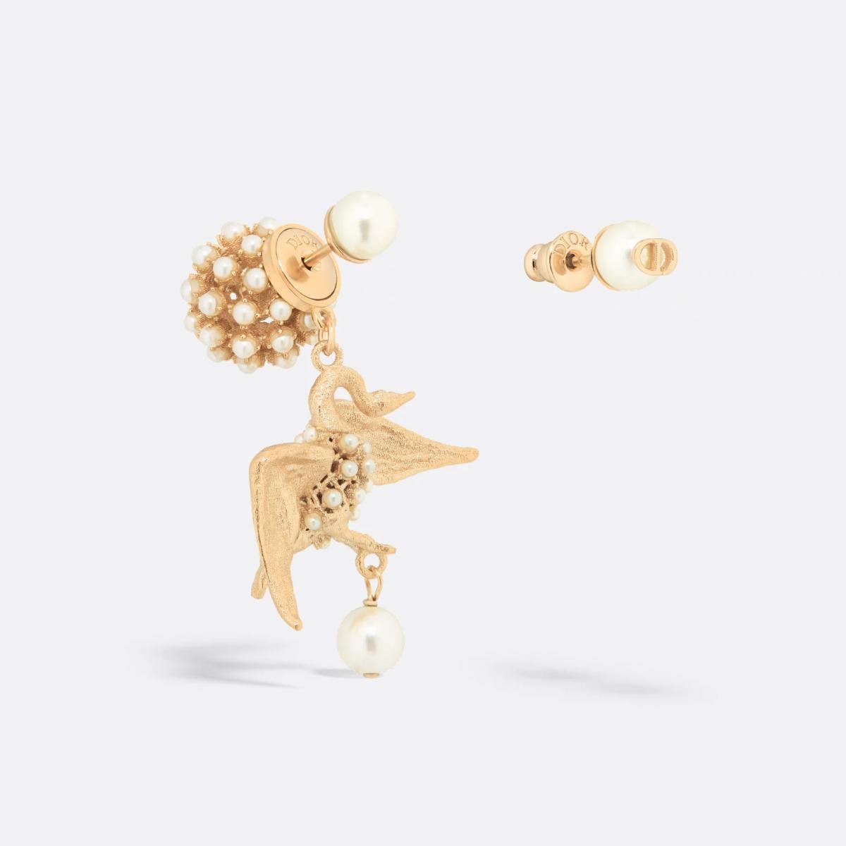 在迪奧的世界裡，浪漫總帶著點戲劇張力。這款 Tribales 耳環以經典珍珠為主軸，一側垂墜金色天鵝，另一側則飾以 CD 標誌，構築出不對稱卻和諧的視覺節奏。天鵝的羽翼上鑲嵌細密珍珠，隨光線閃爍，宛如在耳畔輕舞。這樣的設計，令人不禁聯想到舞蹈系出身的謝盈萱，舉手投足間散發出優雅力量。