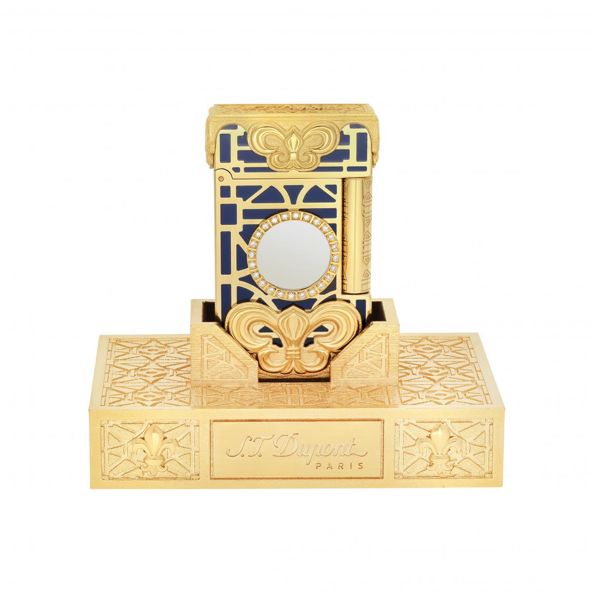 S.T. Dupont 以法國「太陽王」路易十四為靈感打造高訂打火機：藍金相間的亮漆與18K黃金鍍層構築凡爾賽宮般的華麗，中央太陽王獎章以鑽石環繞，象徵權力與榮耀。底座融入宮廷花紋與鳶尾花雕飾，宛如縮小版的皇室珍寶，是結合歷史意象與珠寶工藝的收藏級作品。
