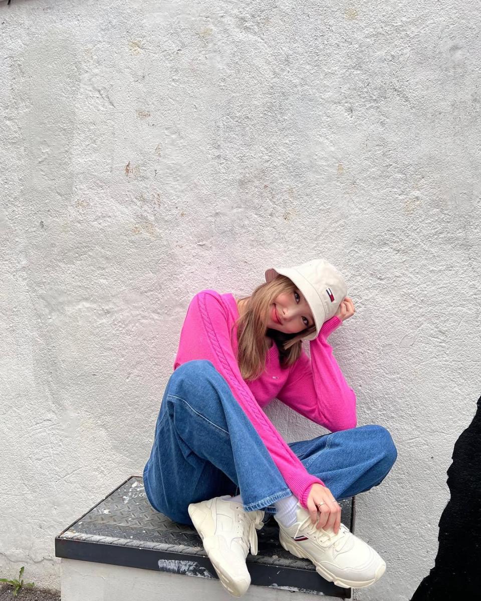 娜璉這套穿搭，運用螢光粉針織毛衣做搭配，搶艷的色彩即便身著的單品都是基本款，也能擁有亮眼的視覺效果。