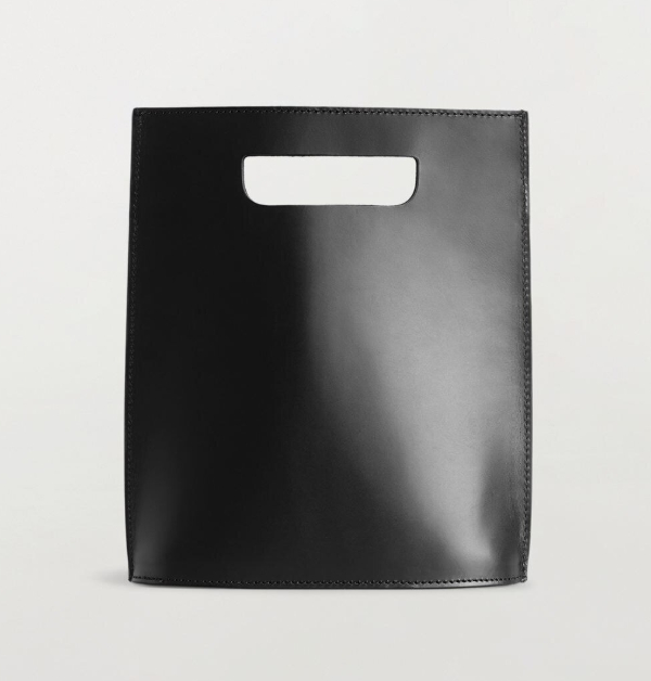 俐落的方形輪廓，簡單中帶有設計感，此款霧面的黑色皮革手提方包，低調卻充滿質感，隨手提著，就能散發出低調優雅的時尚氣息。