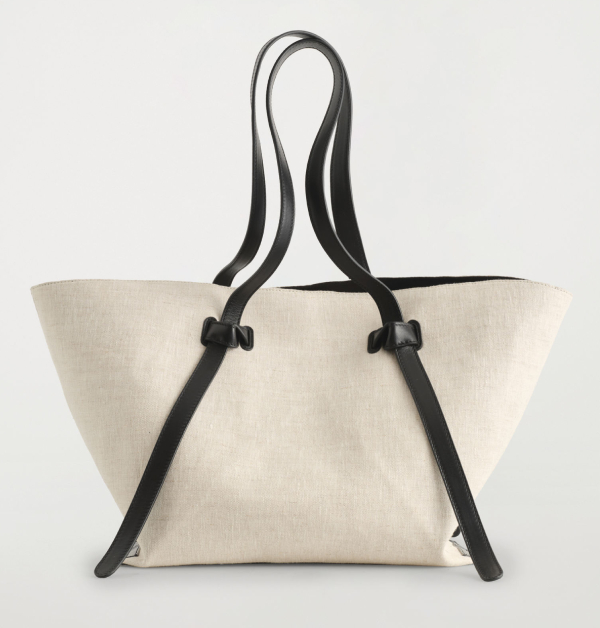 這款托特包採用米白色亞麻材質，搭配皮革細節肩帶，打造兼具美觀與實用的摩登風格單品。而肩帶採用調節設計，讓你可以依據自己需求調整到舒適又穩定的揹法，可說是相當理想的一款時尚出行包袋首選。