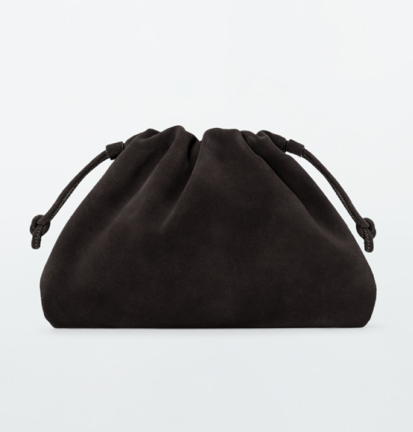 這款手拿包採用柔軟絨面革製成，帶來細膩豐盈的手感。迷你尺寸設計，兩側打結抽繩營造出醒目而柔和的褶皺輪廓，可輕鬆夾在手臂一側，既方便又充滿造型感。