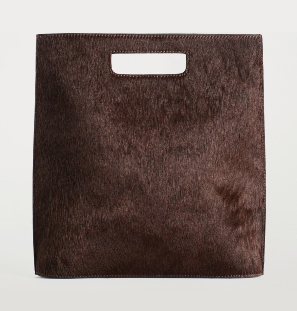 以簡約的幾何線條呈現低調優雅，卻在細節處展現隽永層次感。光澤柔和的馬毛皮革與俐落方正的包身輪廓相互映襯，使整體造型既現代又不失溫潤質感。