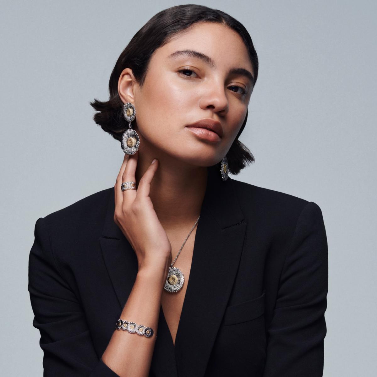 這條項鍊以3.5公分的大雛菊登場，比耳環更放大了花瓣的層次，也更能看清楚 Buccellati 工藝的細節。放大的花瓣像被微風吹開，每一道紋理都清晰得近乎細密的蕾絲；純銀材質搭配中心的金色花蕊，則讓整體散發出不刺眼、卻難以忽視的柔亮光澤。它不像鑽石那樣鋒利耀眼，更像午後陽光透過紗簾灑落下來，溫暖而柔和。 這種視覺存在感，對於走極簡穿搭的人來說剛剛好——白襯衫、薄針織、素面洋裝，只要掛上它，整個造型立刻變得從容又有態度。吊墜雖然尺寸不小，但搭配纖細而俐落的鍊條後，呈現出完美的平衡感，不過度、不失焦，恰好成為胸前的主角。如果你想找一條能讓日常穿搭瞬間升級的 Statement Necklace，這朵大雛菊絕對推薦。