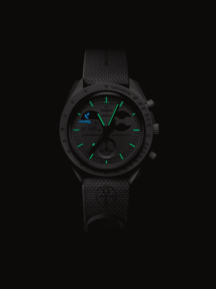 MoonSwatch 的史努比插畫永遠有驚喜，而這次 Cold Moon 版本更把雪景玩出了新花樣。錶盤9點鐘位置的史努比，不再只是坐在月球旁，而是化身在冬夜裡觀賞地球的可愛身影，讓人看一眼就被萌到。品牌也保留經典的 Super-LumiNova® 夜光塗料（綠光）及 UV 隱藏彩蛋（藍光），在無光環境下會浮現出專屬訊息，向 Omega 的登月歷史致敬，也成為錶迷之間最熱衷分享的秘密亮點。這些細節不僅展現 Swatch 的幽默與創造力，也讓腕錶不只是計時工具，而是能讓人會心一笑的故事載體。每次抬腕，都像是跟史努比及糊塗塌客（Woodstock）一起望向遠方的地球。