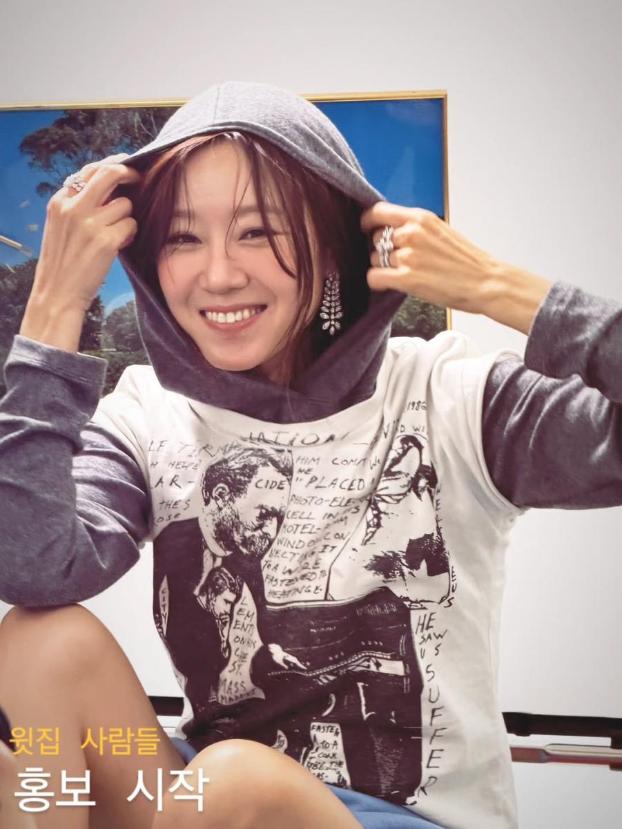 帽T與寬鬆圖像T，是許多人衣櫃裡最放鬆的一組搭配，卻也最容易看起來像居家服。孔孝真的做法很聰明，她保留服裝的隨性輪廓，卻在耳際加入一對存在感明確的吊墜耳環。金屬線條隨著動作微微晃動，彷彿在柔軟棉料中添上一抹亮點，讓視線自然往上集中。略帶華麗感的耳環替休閒穿搭補上一個清楚的重心，使整體看起來輕鬆卻不隨便。這正是混搭最迷人的地方：風格看似衝突，卻意外和諧。