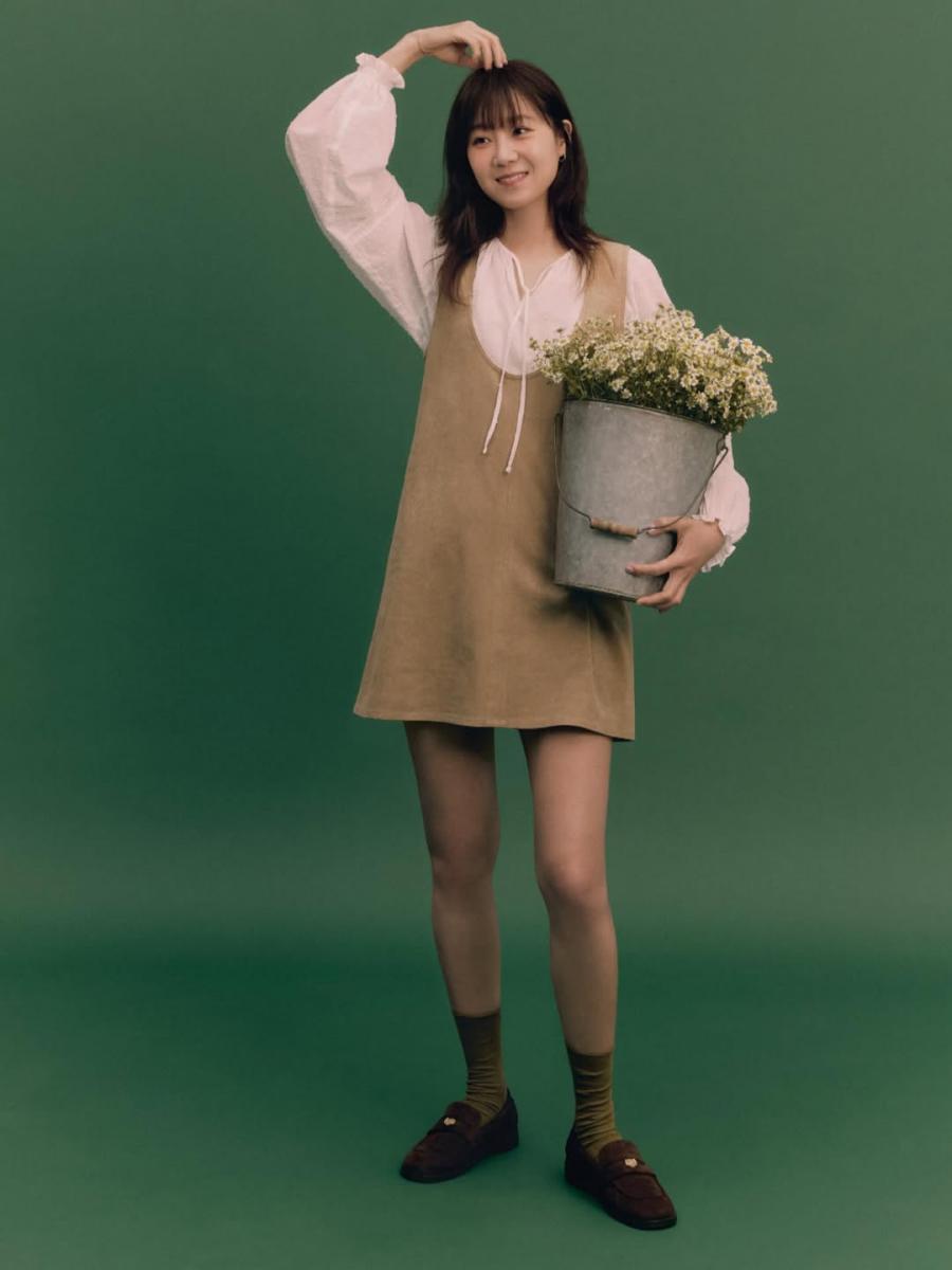 米色背心洋裝搭配白色澎袖上衣，乍看之下很容易走向過度可愛或田園風，但孔孝真的選擇，總會留一點空白給「帥氣」。她在這類偏甜的穿搭中，刻意搭配線條俐落、不帶裝飾感的耳環，削弱過多的浪漫氣息。這樣的配件選擇，就像在甜點裡灑上一點海鹽，讓味道更立體。對於想嘗試這路線甜美穿搭、卻又不想被說成「裝年輕」的人來說，這是一個非常值得記住的平衡技巧。