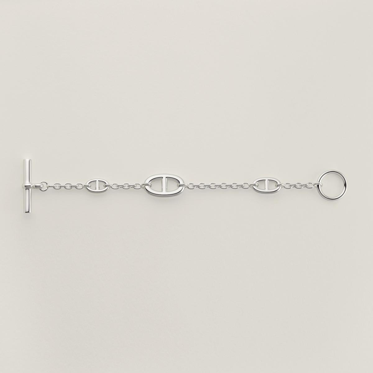 如果說 Enchaînée 系列是力量的凝結，那 Farandole 系列則是節奏的延伸。這款手鍊保留 Chaîne d’Ancre 的經典鍊節比例，卻刻意拉長間距，讓銀鍊在手腕上呈現出輕盈流動的視覺效果。它不像傳統手鍊那樣緊貼，而是隨動作自然擺盪，帶有一種近乎隨性的優雅。法國製造的細膩工藝，讓每一節鏈環都圓潤順手，佩戴舒適度極高。這是一款非常適合日常佩戴的作品，能輕鬆融入牛仔褲、白襯衫等基本單品，卻在細節中默默透露出 Hermès 的品味背景。