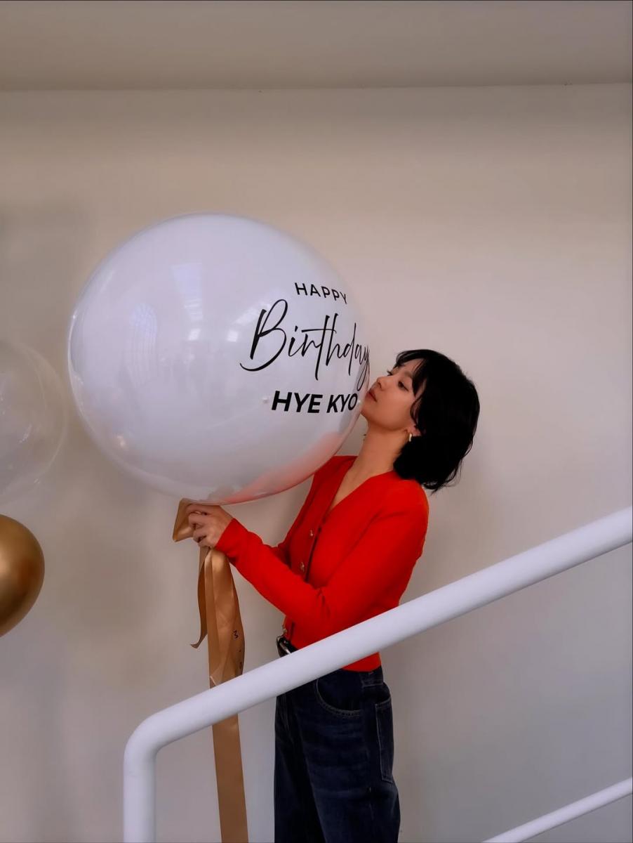 宋慧喬以紅色針織衫作為造型亮點，搭配深色牛仔寬褲，將視覺重心自然拉回上半身。簡潔剪裁讓紅色不顯張揚，反而成為提亮氣色的關鍵，使整體看起來更有精神。她刻意以深色下身收斂份量，讓色彩停留在臉部周圍，在活力與成熟之間取得平衡。這樣的配色思路直接而有效，是不靠技巧、卻能立即見效的減齡穿搭法。