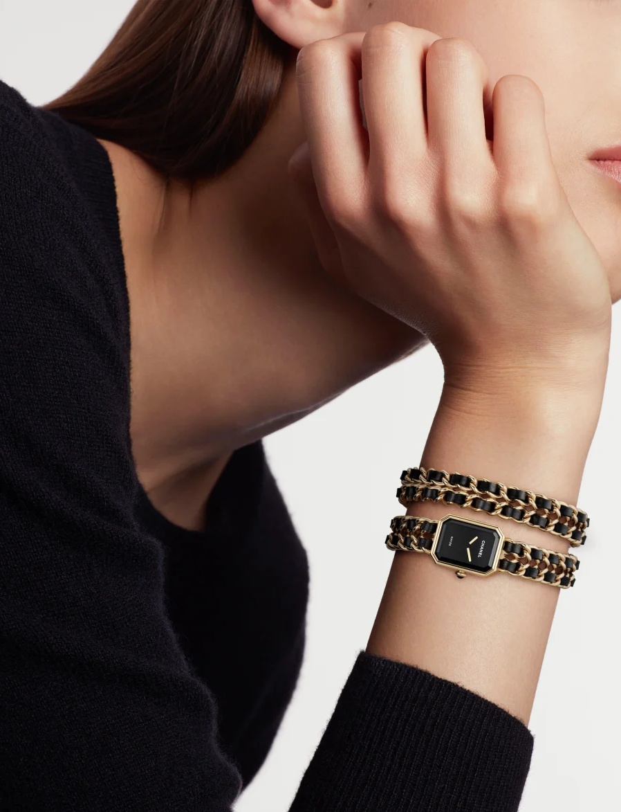 Iconic Chain 是最能代表 Première 靈魂的系列。皮革與金屬鍊條交織的錶帶，直接向香奈兒經典包款致敬，讓時間像包包一樣被穿戴。黑色漆面錶盤安靜而純粹，捨去時標後，讀時成了一個近乎直覺的動作。26.1 × 20 毫米的錶殼比例貼合手腕，精鋼或黃金塗層款各自呈現不同氣質；前者俐落摩登，後者則帶著巴黎式的溫潤光澤。此系列之所以迷人，在於它以飾品姿態融入造型。從雙圈鍊帶、項鍊錶、手鐲錶，到腰鍊與 Sound 耳機項鍊錶，Iconic Chain 讓時間離開腕部的單一位置，在身體不同節點自由流動。它就像一句反覆被引用的經典，每次佩戴都有不同解讀。