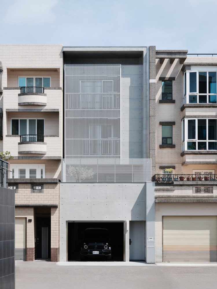 坐落於台南市巷弄之中，一座極簡灰階的建築量體——House Kuo，靜靜地佇立於街區之間。在左首設計的操刀下，設計團隊嘗試為一棟狹長型連棟住宅賦予更多可能性。跳脫傳統老宅的既定印象，透過量體的堆疊與退縮，並揉入格柵設計，賦予立面豐富的視覺層次。隨著時間推移與光線轉換，建築展現出一抹恬靜的詩意，營造出安定而舒適的生活感受，不僅是一處居所，更是一種生活狀態的呈現。