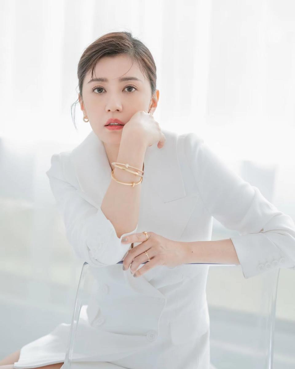 全白西裝套裝本身就極度考驗氣質，一不小心就容易顯得過於正式或距離感十足，但賈靜雯巧妙地用珠寶替造型注入溫度。她選擇以 Tiffany & Co. 的高級珠寶作為點綴，溫潤的金屬光澤在白色布料映襯下顯得格外柔和，也讓整體視覺多了一層層次。金色不張揚，卻能自然提亮膚色，讓全白造型看起來更有精神。這樣的搭配不靠繁複設計取勝，而是以簡潔線條與質感珠寶完成收尾，成熟卻不顯老，反而流露出一種從容而自信的減齡魅力。