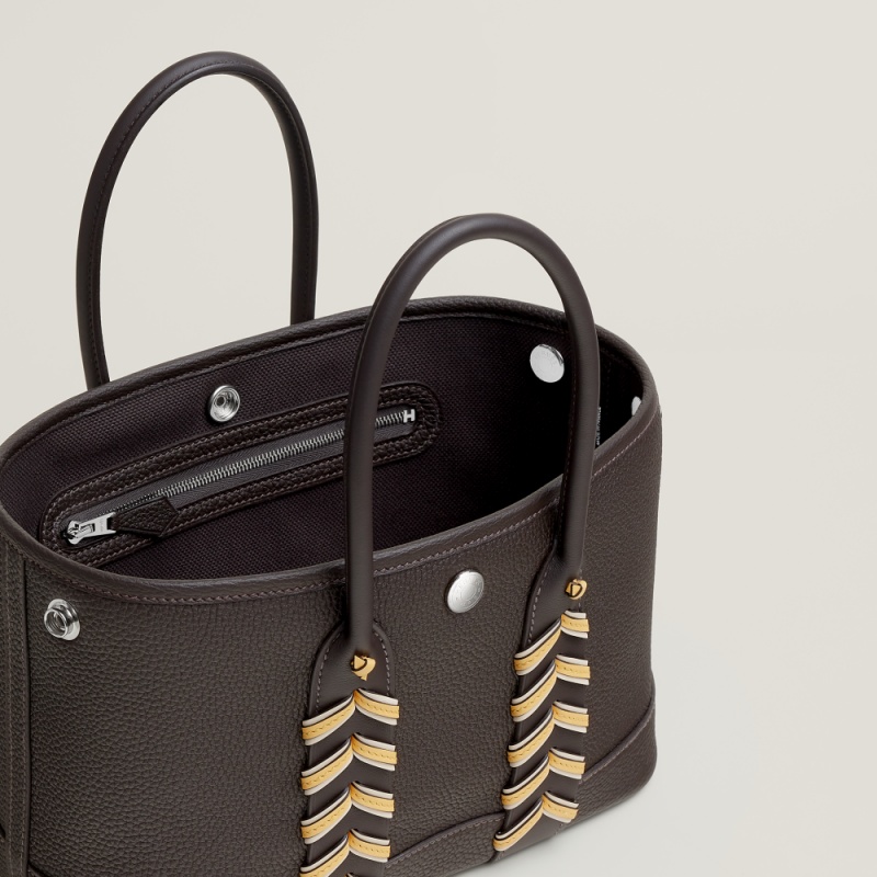 其包袋命名中的「Bredies」，便是意指著該包款上的最大亮點 —— 編織。不同於以往我們對於「Garden Party」系列包款簡潔的意象，這款包再提把的銜接處加入了雙色的皮革編織細節