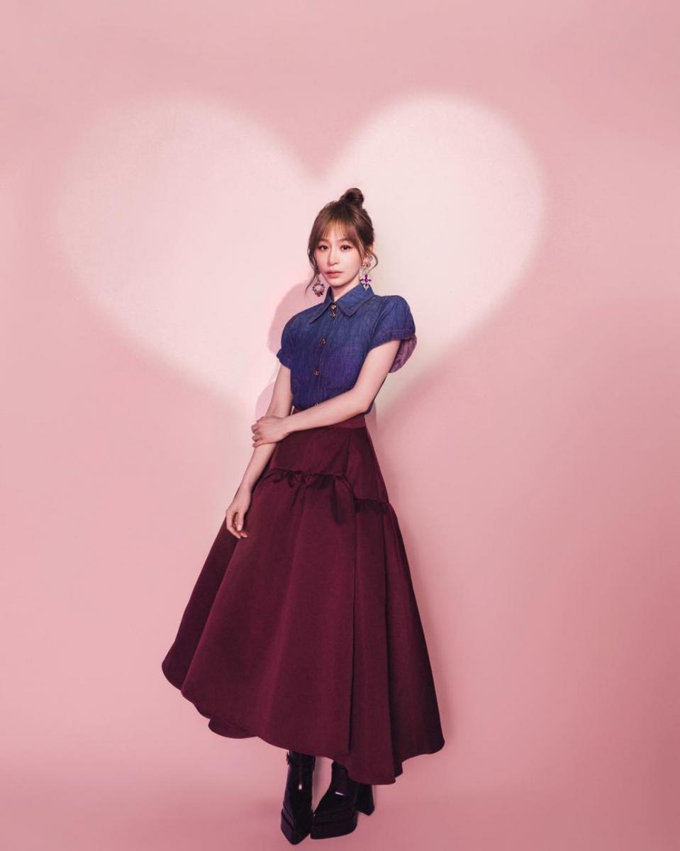 長裙並不是小隻女孩的禁區，關鍵在於怎麼穿。這套造型很聰明，將短版丹寧襯衫刻意收在腰線之上，讓身體的起點被明確標示出來，下身的酒紅色大寬裙則從高腰位置自然展開，裙擺一路向下延伸，自然拉長腿部比例。王心凌選擇硬挺但不厚重的丹寧材質，讓上半身保有結構感，不會被蓬鬆裙擺吃掉比例；酒紅色長裙則利用色彩重量，穩住下盤線條。搭配厚底尖頭高跟短靴，讓裙長不落地、保留腳踝與鞋底的視覺空間，即使是長裙造型，小隻女孩依然能穿出俐落、不拖沓的顯高效果。