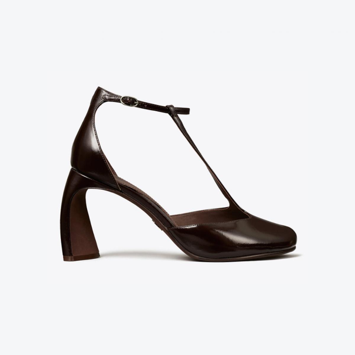 這雙露趾 T 字帶高跟涼鞋，將性感拆解為結構與比例的精準拿捏。T 字帶設計在視覺上自然延伸腿部線條，露趾剪裁則替整體注入輕盈感，即使搭配高跟也不顯厚重。鞋跟高度刻意收斂，讓行走時仍保有穩定與舒適。它是一雙能從白天一路穿到晚上的實用款式，搭配洋裝時展現優雅線條，與褲裝組合則能柔化輪廓、強調女性曲線，非常推薦給都會摩登女性。